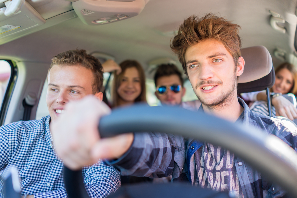 Young people having vacation enjoying fun driving car